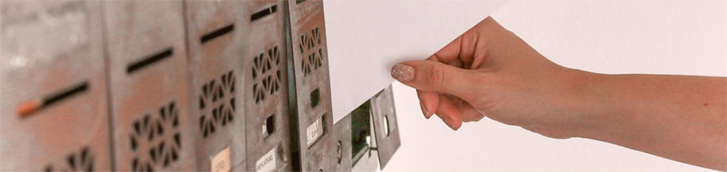 Hand placing envelopes into a post box