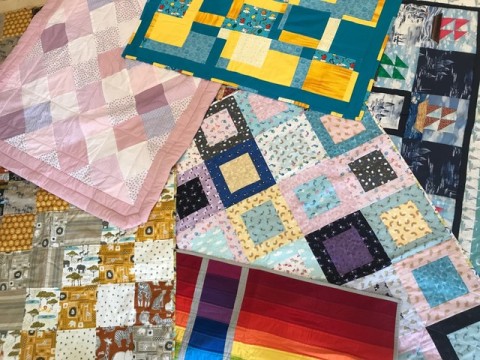 Brightly coloured quilts made from squares of fabric